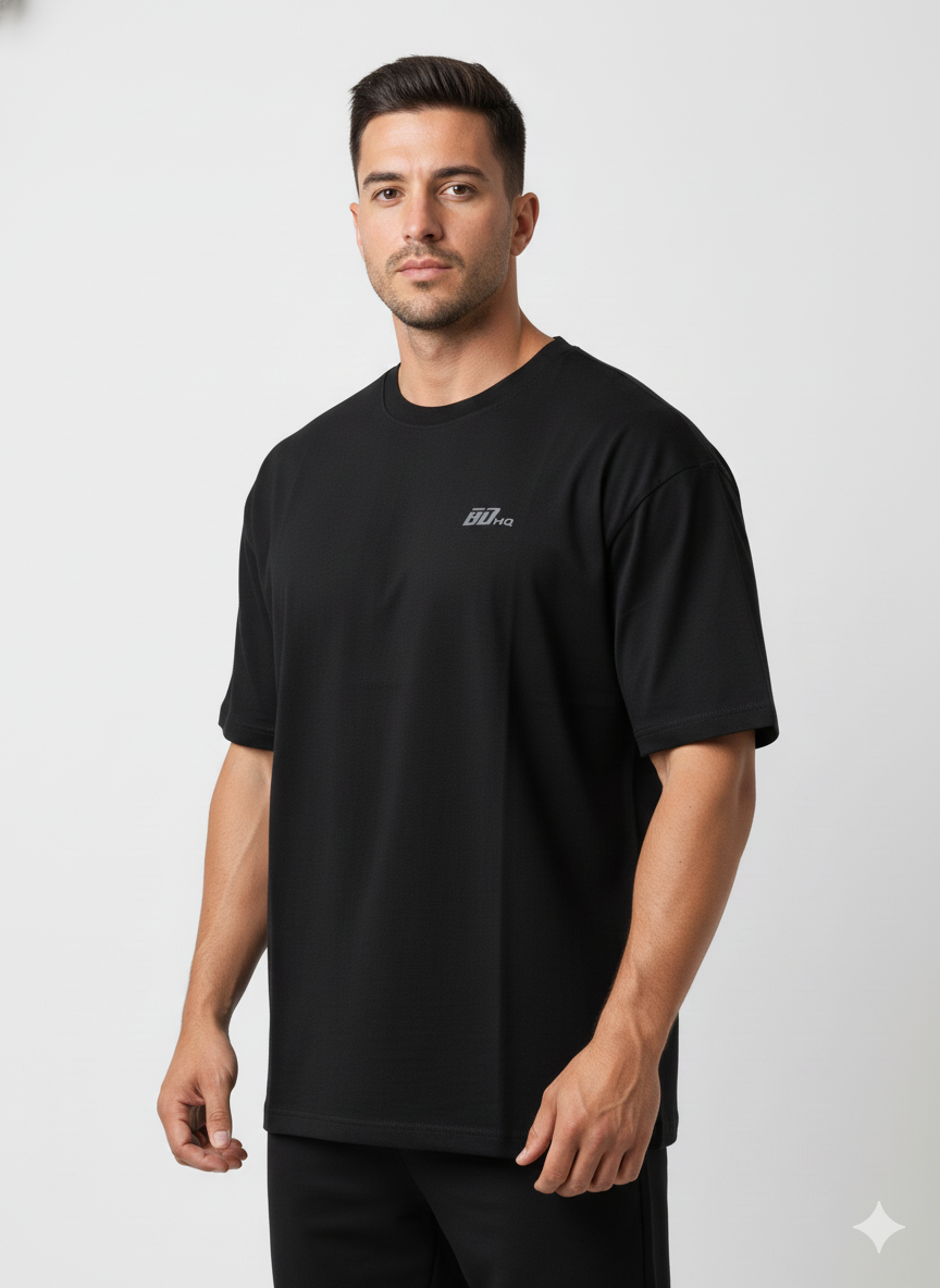 A man faces forward against a white background, wearing the Men's Gym Clothes AU BDHQ Oversized T-Shirt (180GSM) with a lightweight drop-shoulder cut in black and matching black pants, featuring a small chest logo.