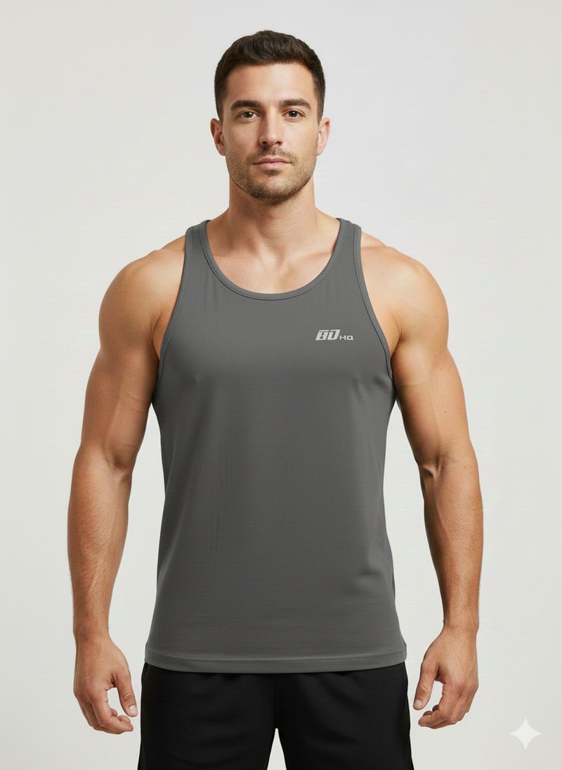 A man with short dark hair and a neutral expression models the BDHQ: Racer Back Vest (180GSM) – Classic Cut, Lightweight Stretch by Men's Gym Clothes AU, featuring “80-10” on the chest, standing against a plain light background.